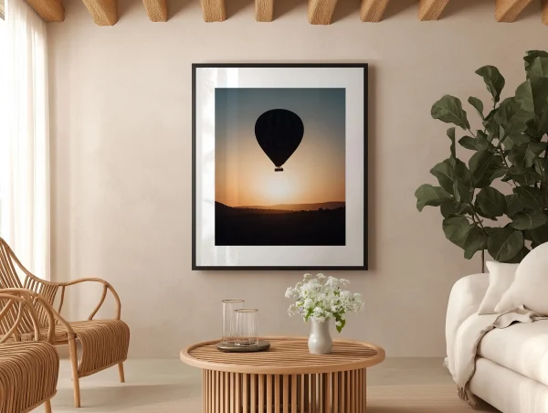 Cadre noir Cappadoce dans un salon de style naturel avec meubles en rotin et plantes.