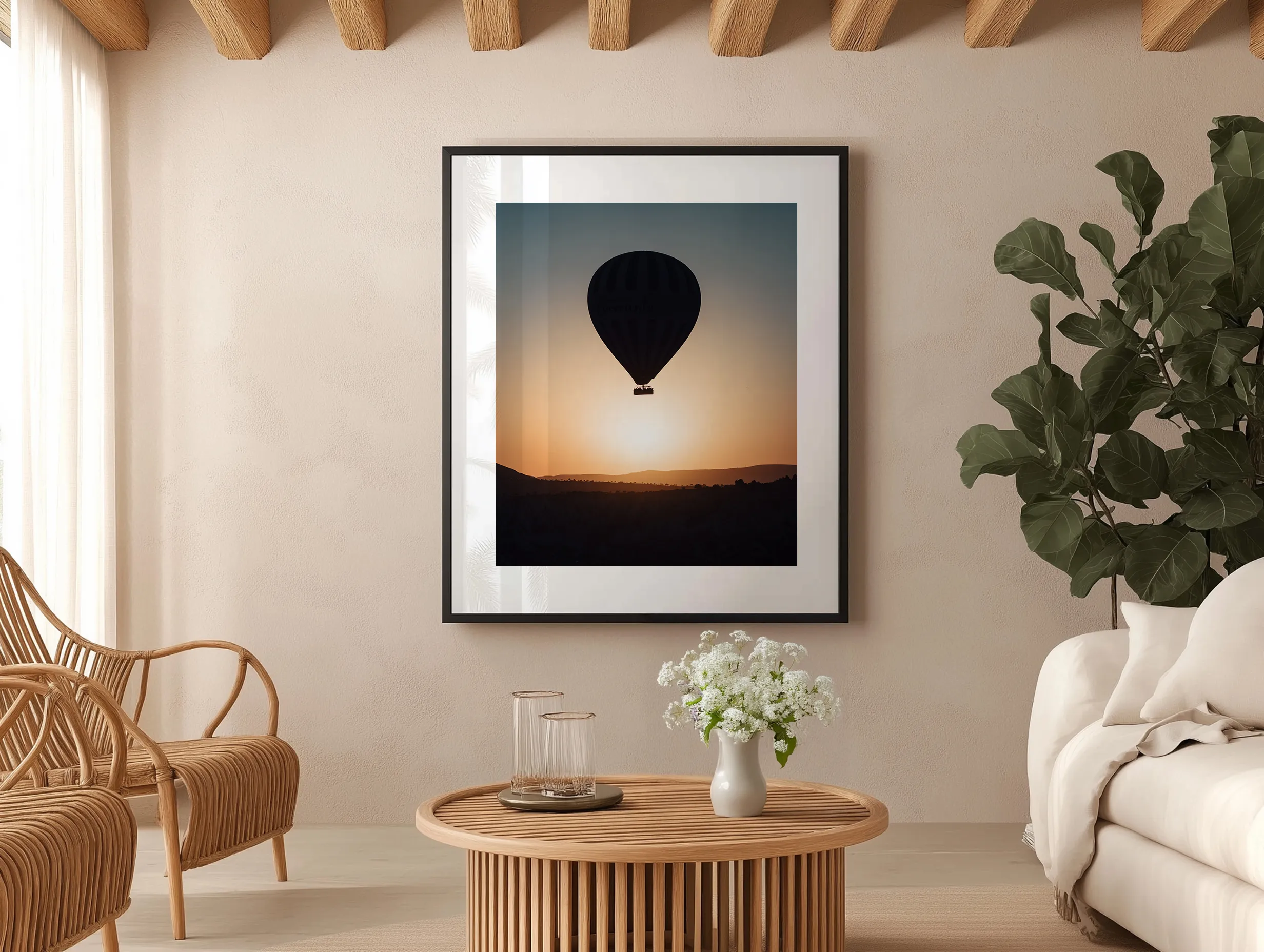 Cadre noir Cappadoce dans un salon de style naturel avec meubles en rotin et plantes.