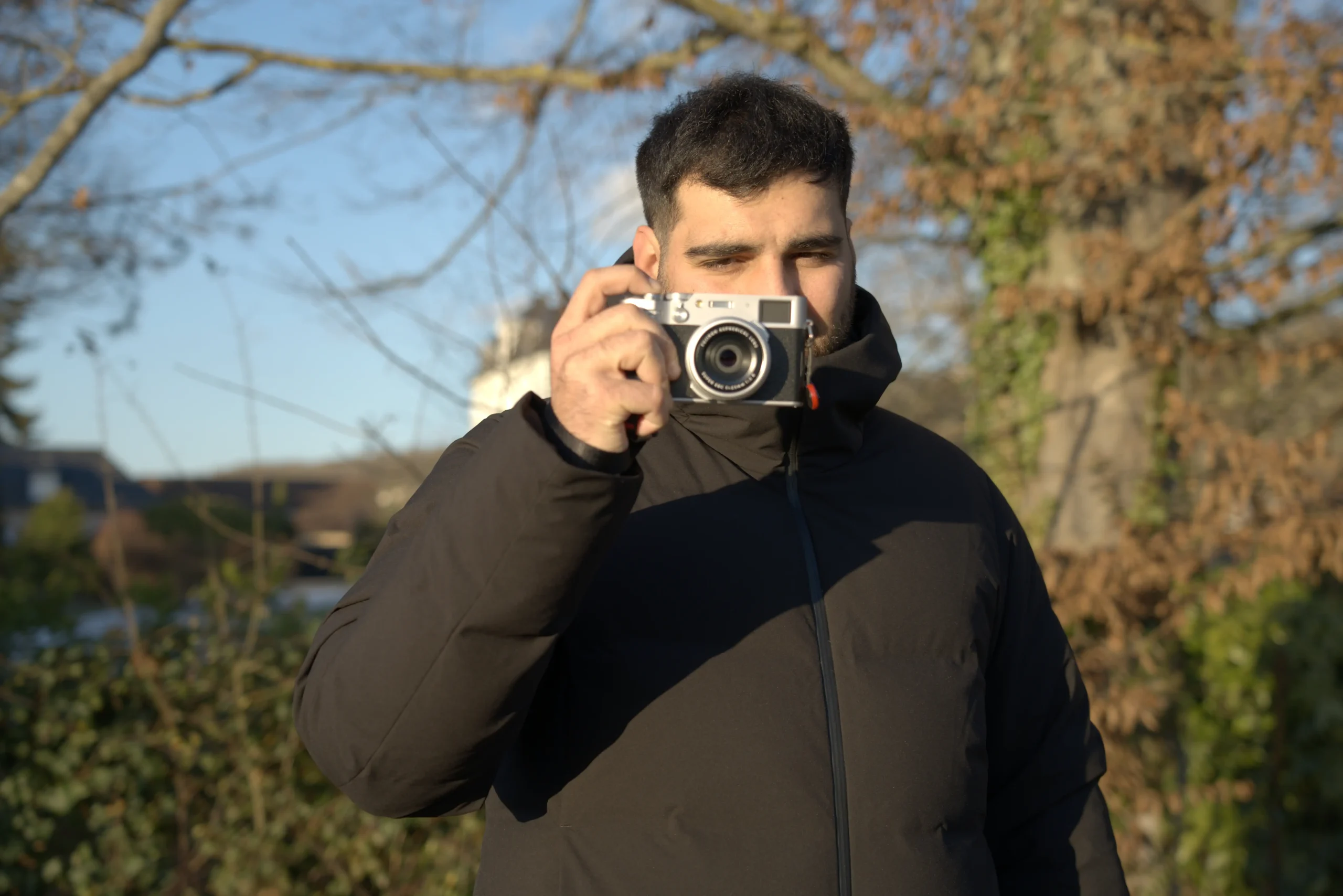 Homme tenant un appareil photo en mode portrait 